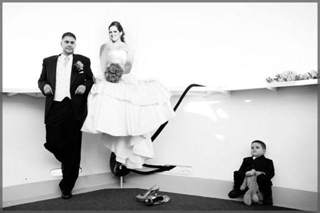 Black and white picture of bride, groom and ring bearer on the bow of the ship.